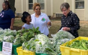 Kelly distributes food at farm and affordable market on Plains Tour
